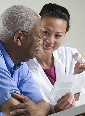 Healthcare provider talking to man about prescription medication.