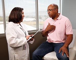 Healthcare provider talking to man in exam room.